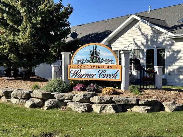 community / neighborhood sign featuring a lawn