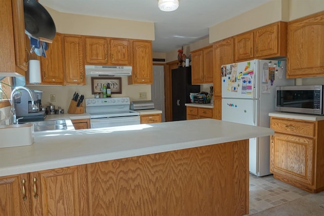 kitchen featuring sink, kitchen peninsula, and white appliances