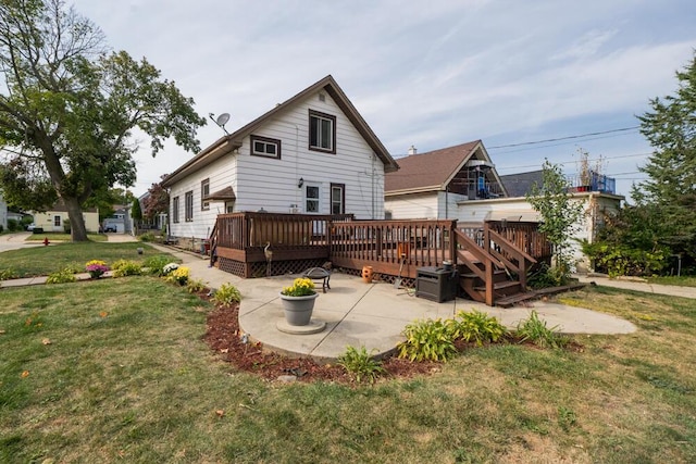 rear view of property featuring a yard, a patio area, and a deck