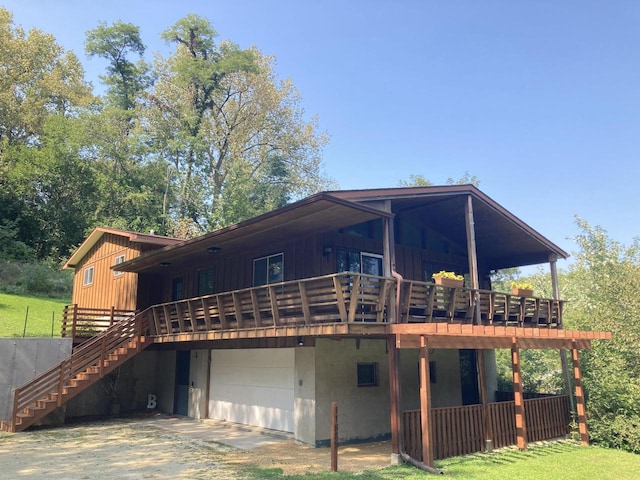 rear view of house with a deck and a garage