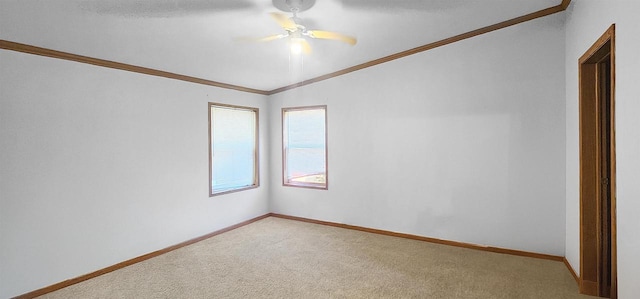 empty room featuring ornamental molding, ceiling fan, carpet flooring, and vaulted ceiling