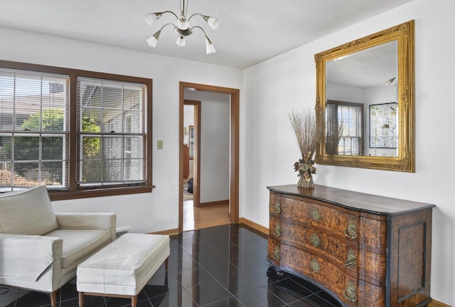 sitting room with a notable chandelier and dark tile patterned flooring