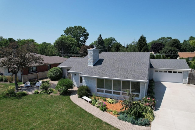 view of front of home with a garage, a sunroom, and a front lawn