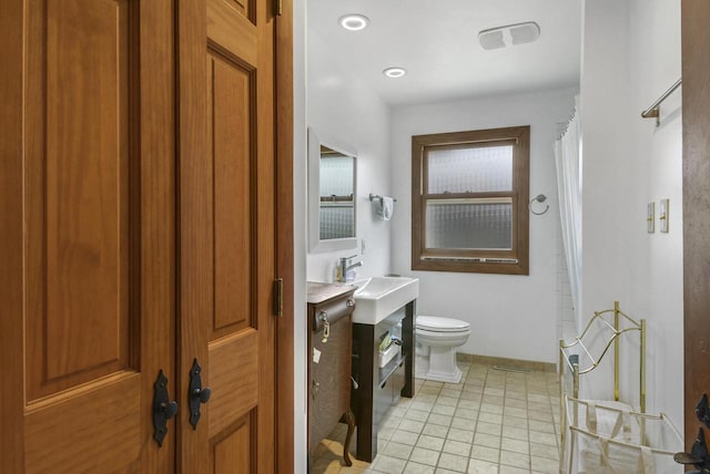 bathroom featuring tile patterned flooring, a shower with curtain, vanity, and toilet