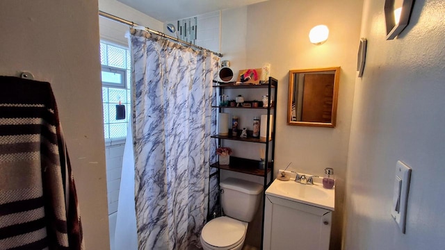 bathroom featuring vanity, toilet, and walk in shower