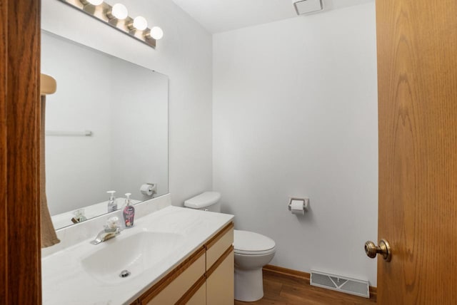 bathroom with vanity, toilet, and wood-type flooring