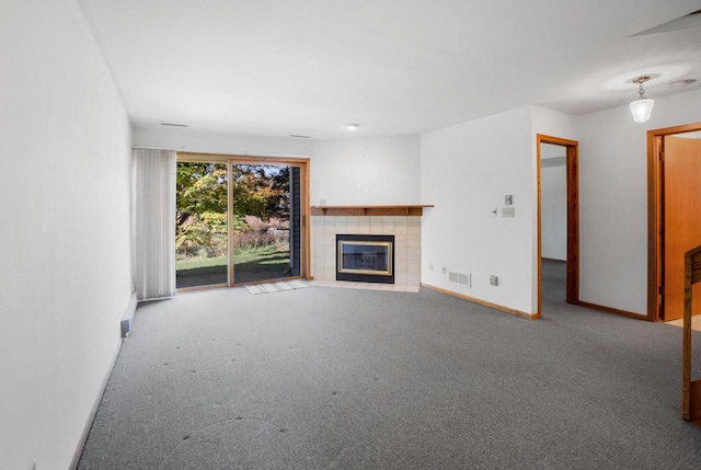 unfurnished living room with carpet and a tile fireplace