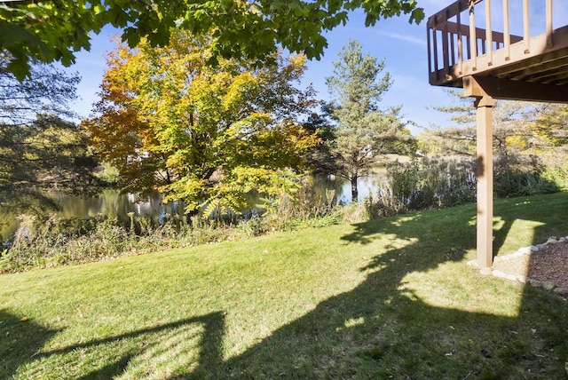 view of yard with a deck with water view