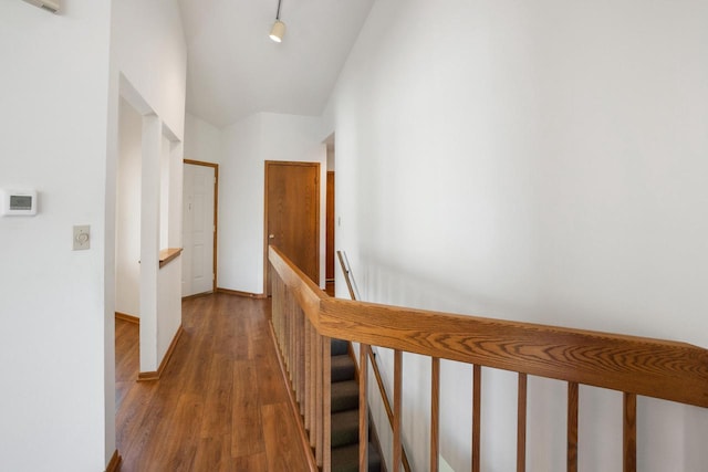 hall with track lighting and wood-type flooring