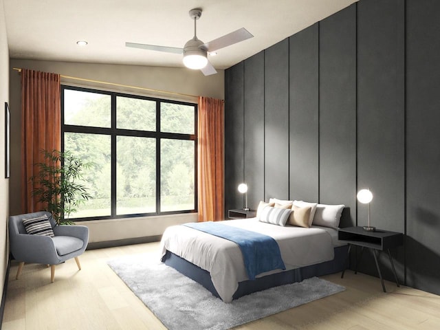 bedroom featuring light hardwood / wood-style flooring, ceiling fan, multiple windows, and lofted ceiling