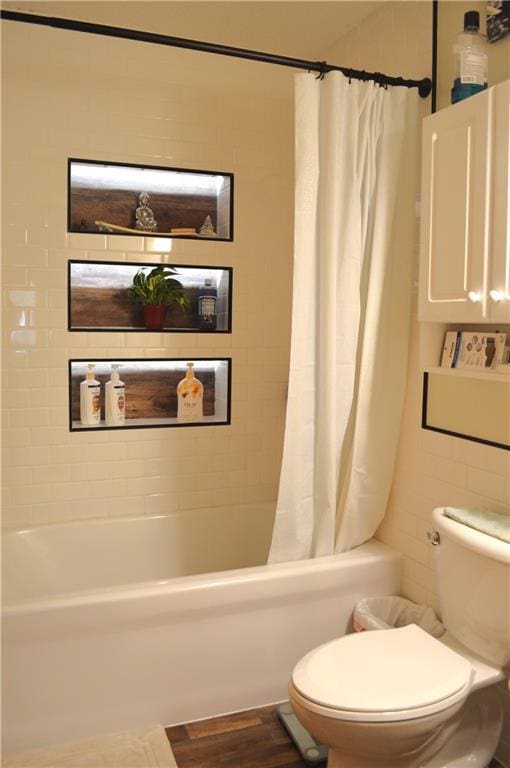 bathroom featuring toilet, hardwood / wood-style flooring, and shower / bath combo with shower curtain