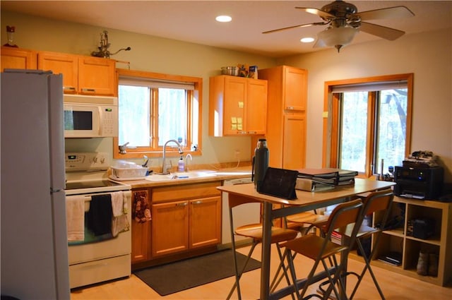 kitchen featuring white appliances, ceiling fan, sink, and light brown cabinets