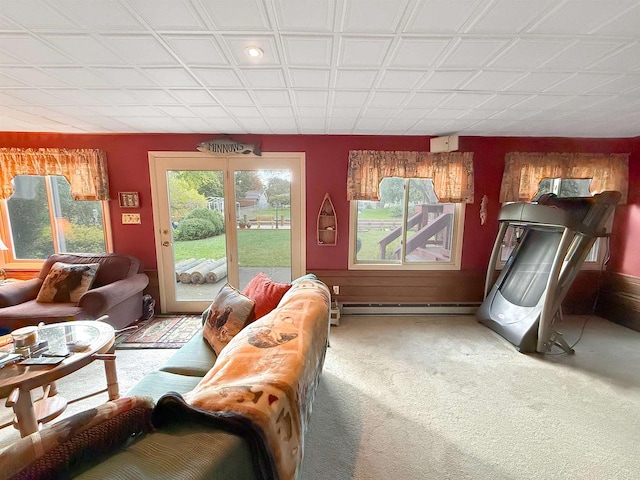 living room with carpet, a baseboard heating unit, and a healthy amount of sunlight