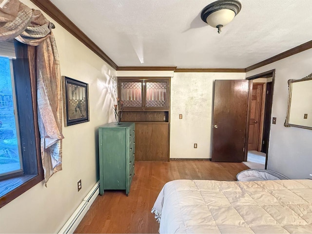 bedroom featuring ornamental molding, a textured ceiling, hardwood / wood-style flooring, and a baseboard heating unit