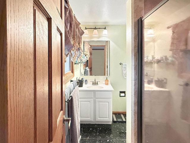 bathroom featuring a shower with door and vanity