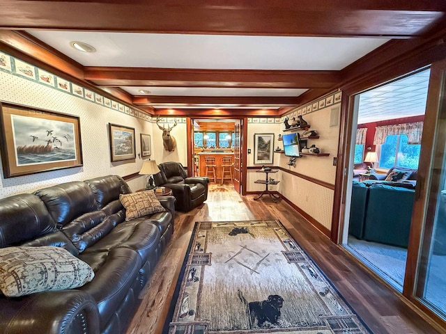 living room featuring bar, beamed ceiling, and wood-type flooring