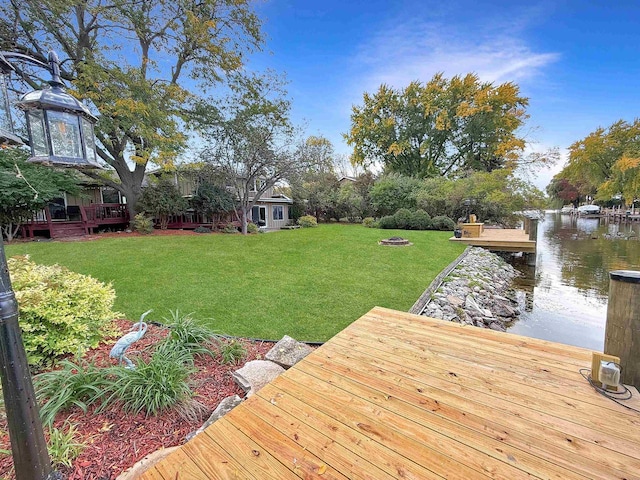 dock area with a yard and a water view