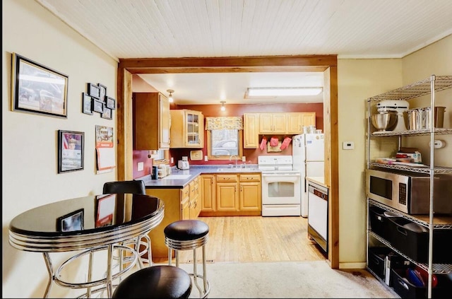 kitchen featuring white appliances, light brown cabinetry, light hardwood / wood-style flooring, and sink