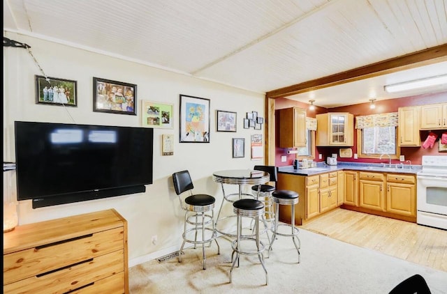 kitchen with light brown cabinets, beamed ceiling, white electric range, sink, and light wood-type flooring