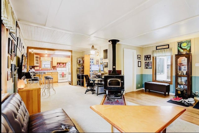 living room with light hardwood / wood-style flooring and a wood stove