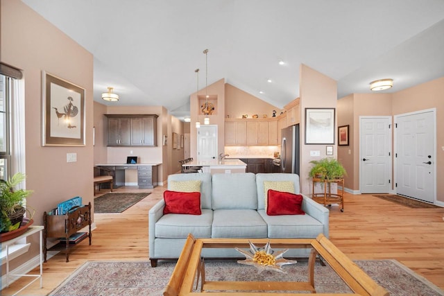 living room with light hardwood / wood-style flooring and high vaulted ceiling