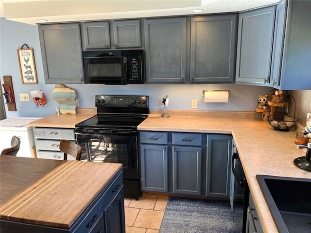 345 Old County D, Shell Lake, WI 54871 - kitchen with light countertops, light tile patterned floors, and black appliances