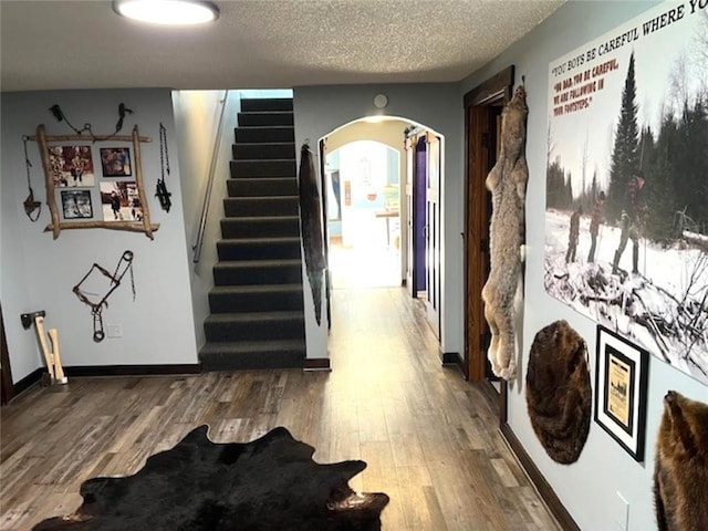 345 Old County D, Shell Lake, WI 54871 - hall with stairway, arched walkways, wood finished floors, and a textured ceiling