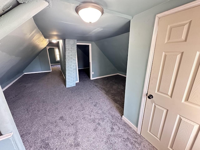 bonus room with vaulted ceiling and dark colored carpet