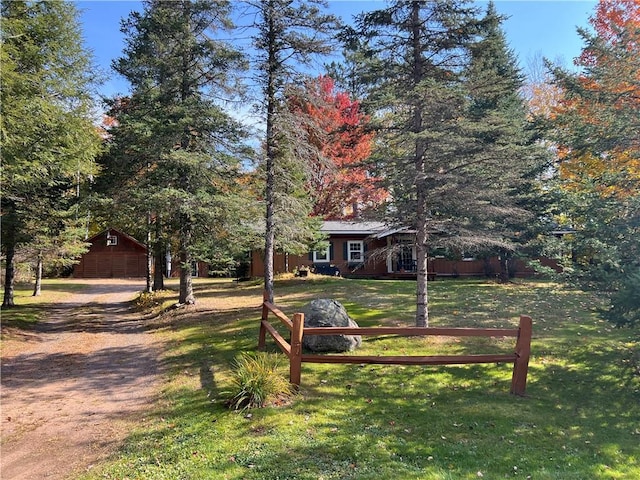 view of front of property featuring an outbuilding, a front lawn, and a garage