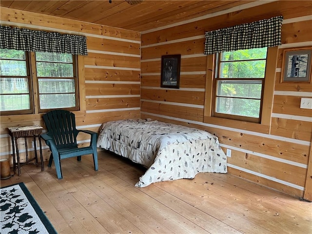 bedroom featuring wood walls, wood-type flooring, and wooden ceiling