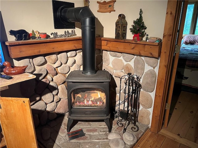 room details with hardwood / wood-style floors and a wood stove