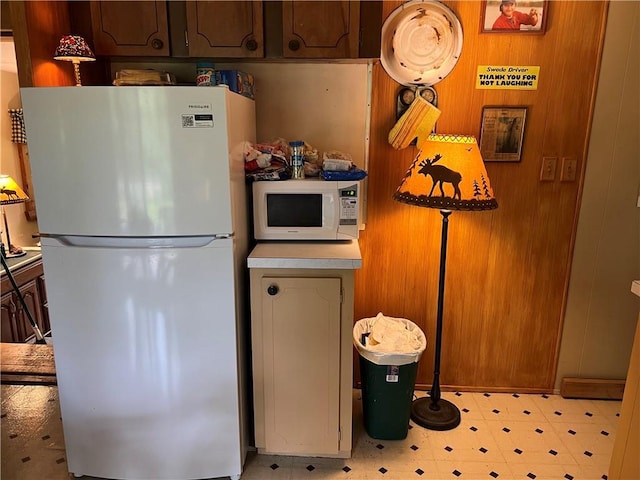 kitchen with white appliances and wood walls