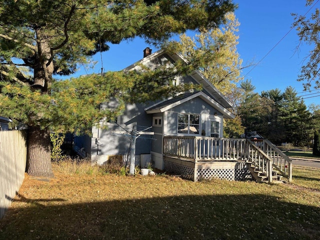 rear view of house featuring a yard and a wooden deck