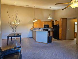 kitchen featuring kitchen peninsula, black appliances, decorative light fixtures, carpet flooring, and ceiling fan