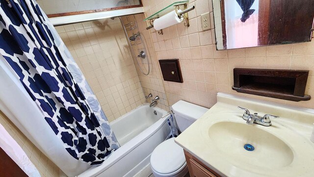 full bathroom with tile walls, vanity, shower / bath combo with shower curtain, and toilet