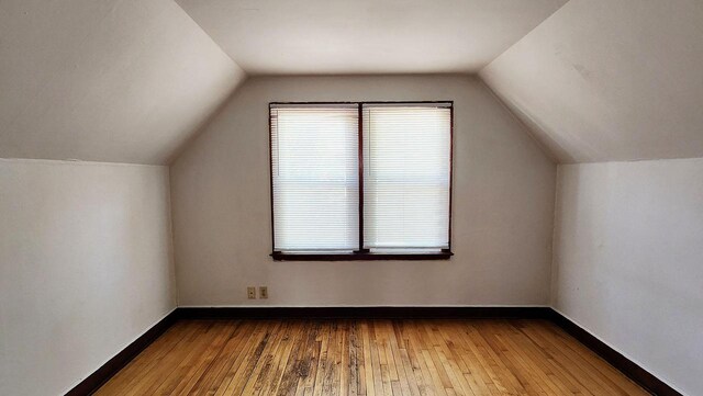 bonus room featuring vaulted ceiling and wood-type flooring