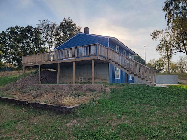 back house at dusk with a deck and a yard