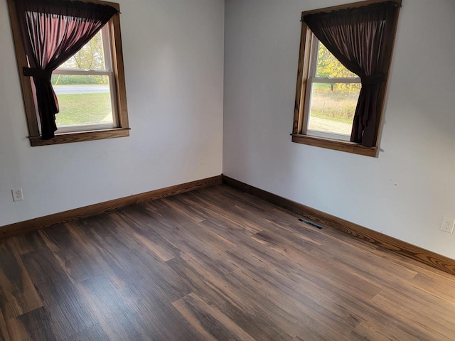 unfurnished room featuring dark hardwood / wood-style floors and plenty of natural light