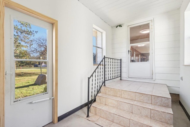 stairway featuring a wealth of natural light and concrete floors