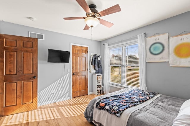 bedroom with light hardwood / wood-style flooring and ceiling fan