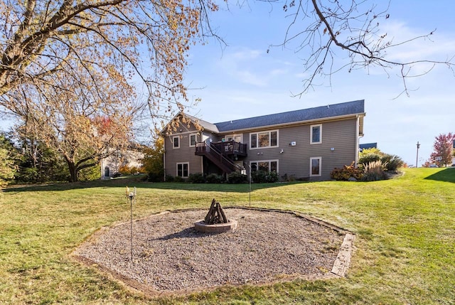 back of house with an outdoor fire pit, a deck, and a yard