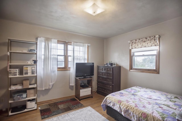 bedroom with light hardwood / wood-style flooring and multiple windows