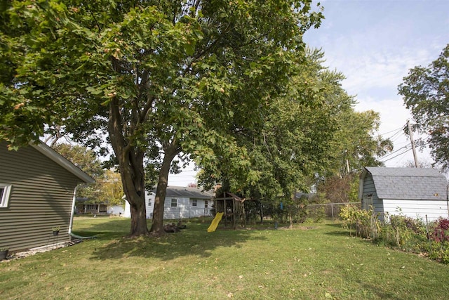 view of yard with a storage unit and a playground