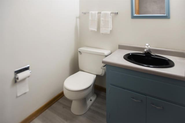 bathroom with vanity, wood-type flooring, and toilet