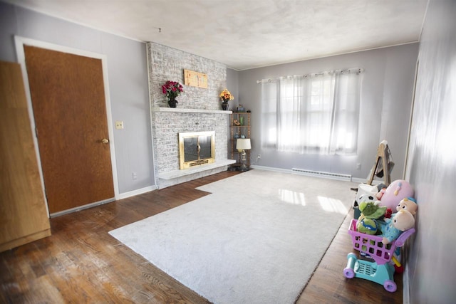 living room featuring baseboard heating, wood-type flooring, and a fireplace