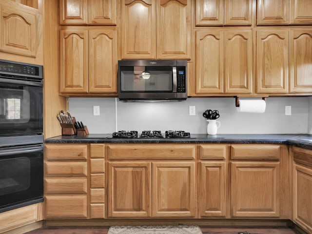 kitchen featuring black appliances and dark hardwood / wood-style flooring