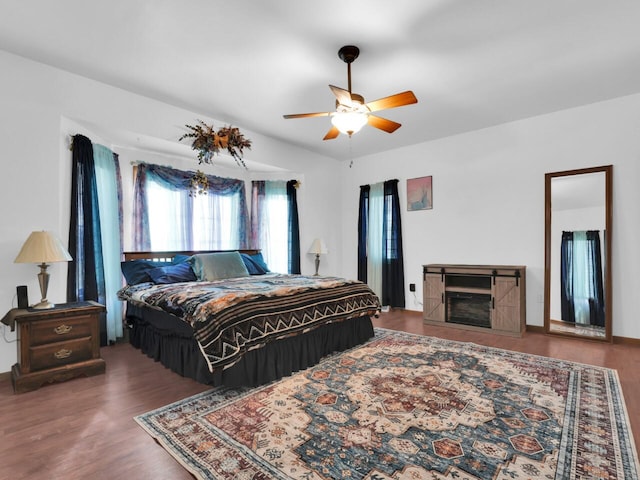 bedroom with dark hardwood / wood-style flooring and ceiling fan