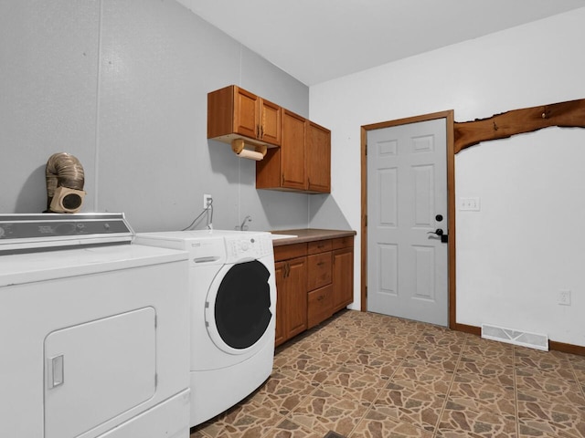 washroom featuring cabinets, sink, and independent washer and dryer