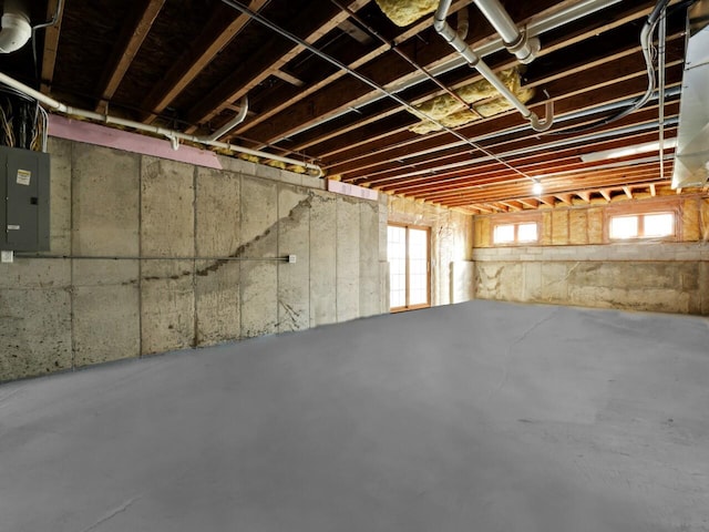 basement featuring electric panel and plenty of natural light