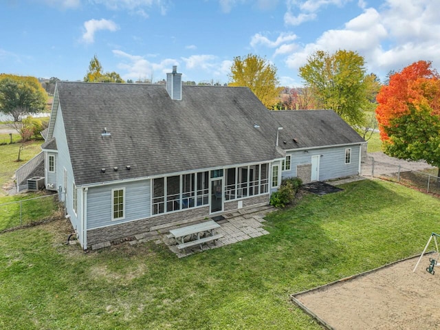 back of house featuring a patio area, a sunroom, and a yard